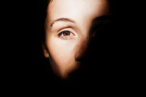 Close-up of a person’s face half in shadow, symbolizing trauma and emotional distress before healing through EMDR therapy.