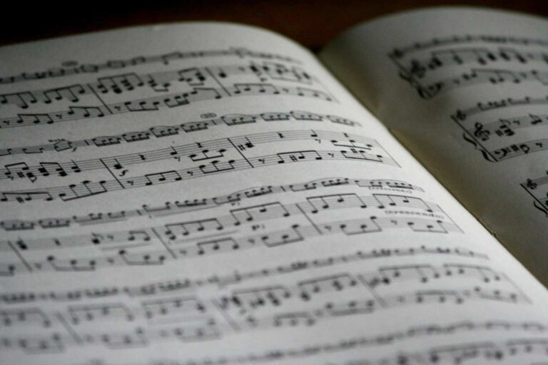 Open book of sheet music with musical notes, representing the role of music in therapy and healing.