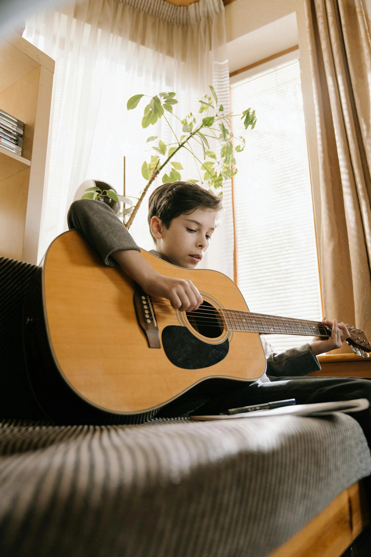 Boy engaging in Nordoff treatment guitar play in music therapy Austin TX for emotional growth and resilience skills