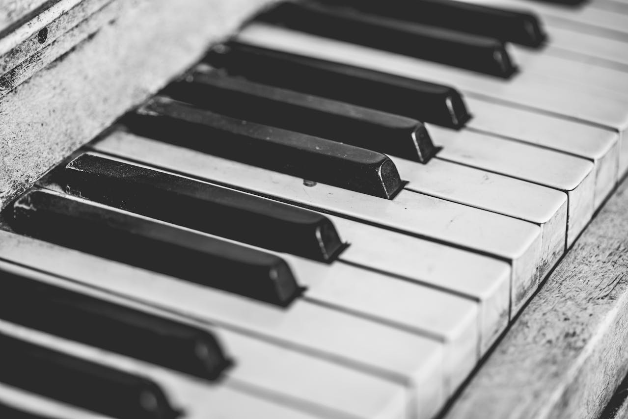 Black and white close-up of piano keys symbolizing the role of melody and rhythm in music therapy for autism.