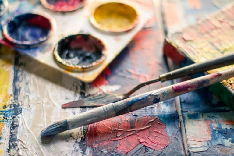 Paint brushes and art palette symbolizing creative arts therapy for children, supporting emotional expression, creativity, and healing through art.
