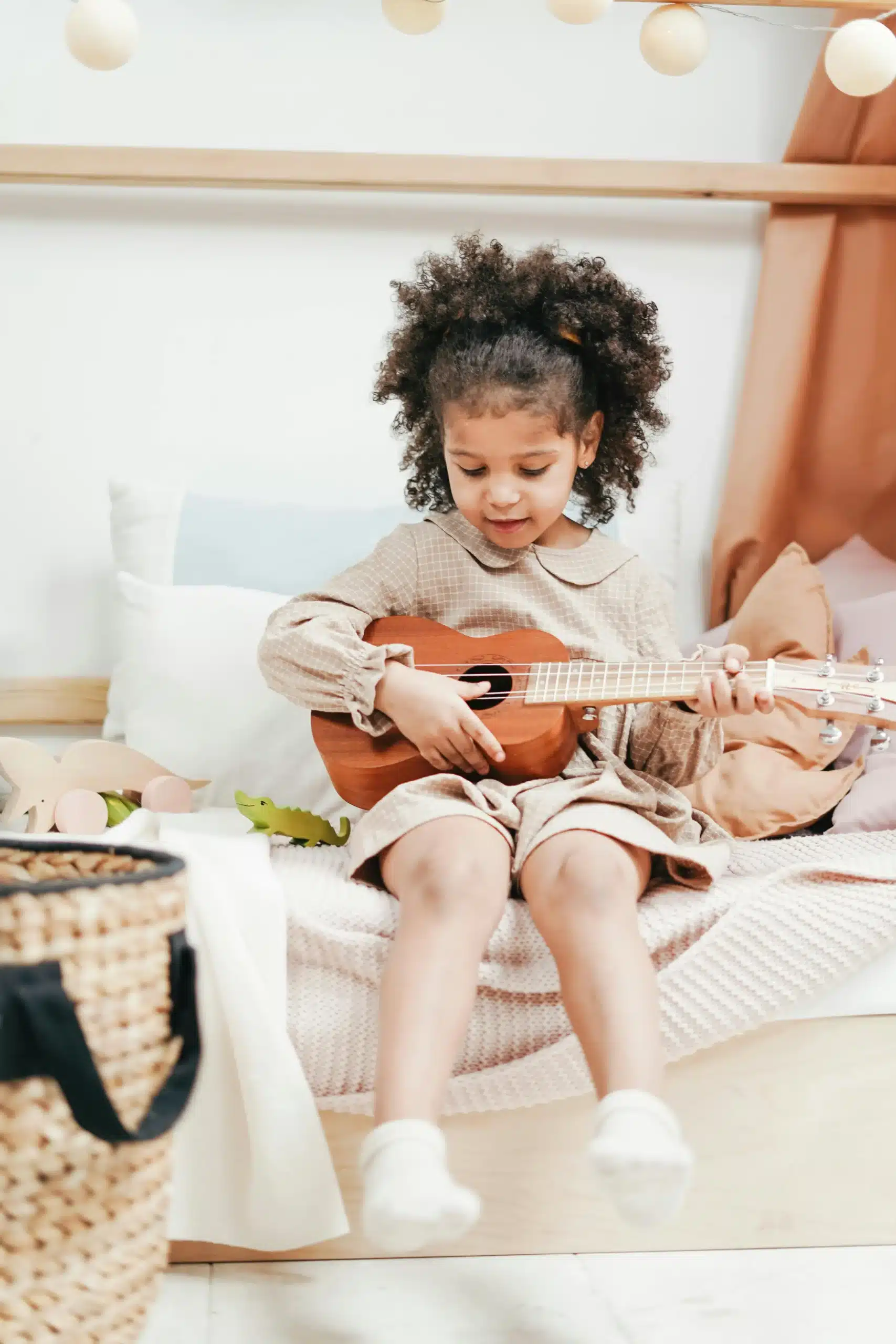 Young African American girl playing guitar expressing creativity confidence and emotional growth through music play daily