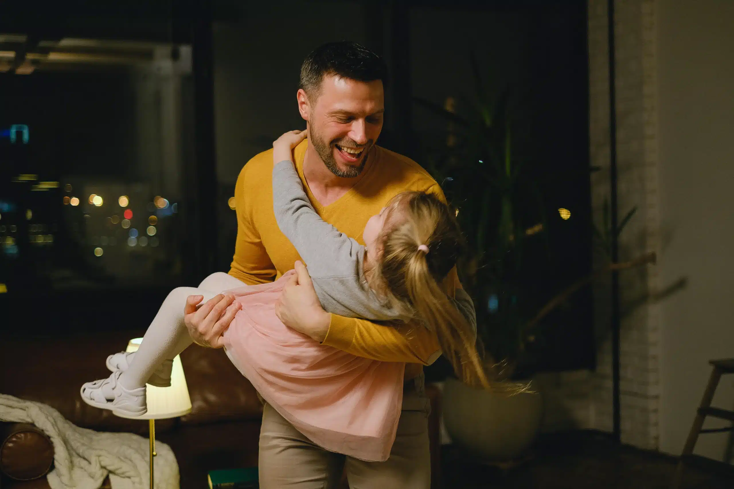 Father holding daughter smiling warmly creating connection safety and secure attachment in loving family bond moment
