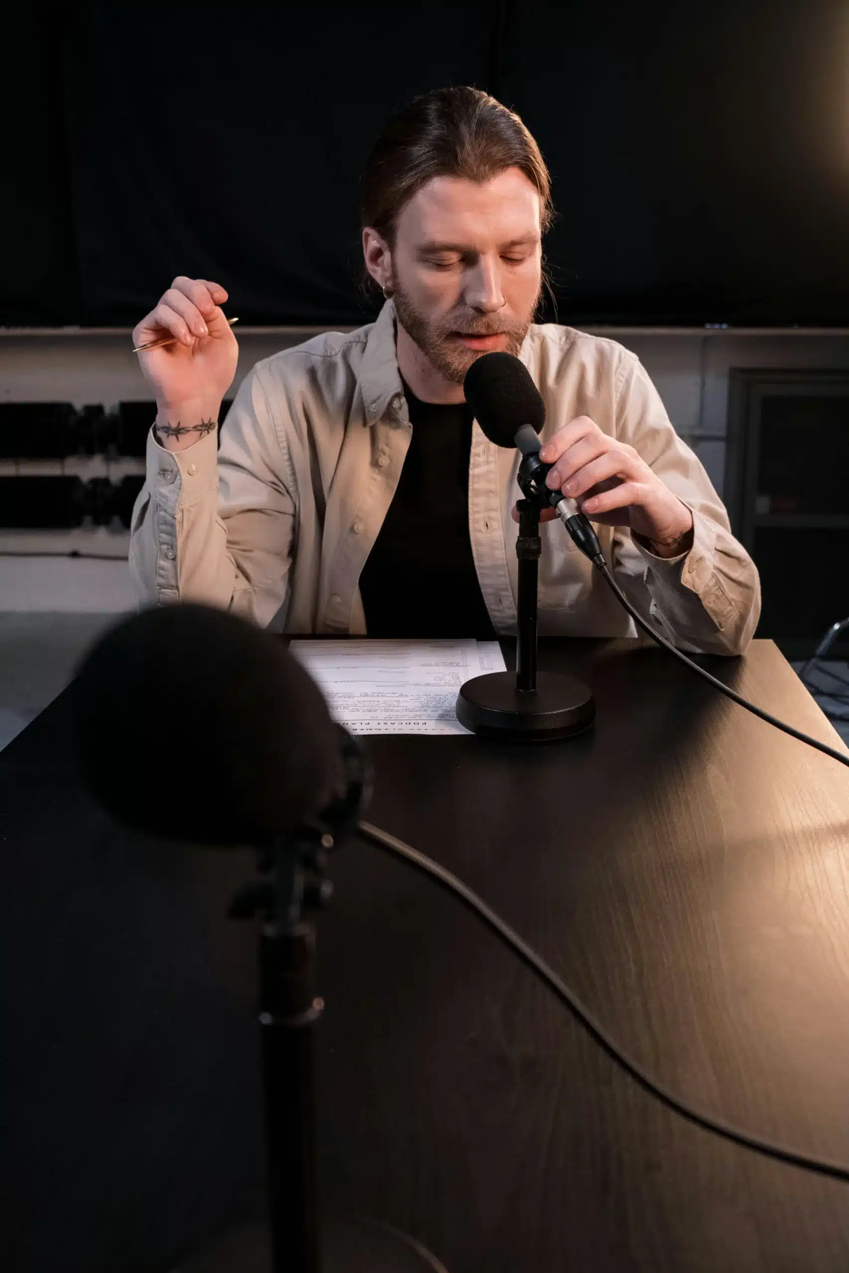 A man speaking into a microphone, expressing communication, creativity, and confident self-expression.