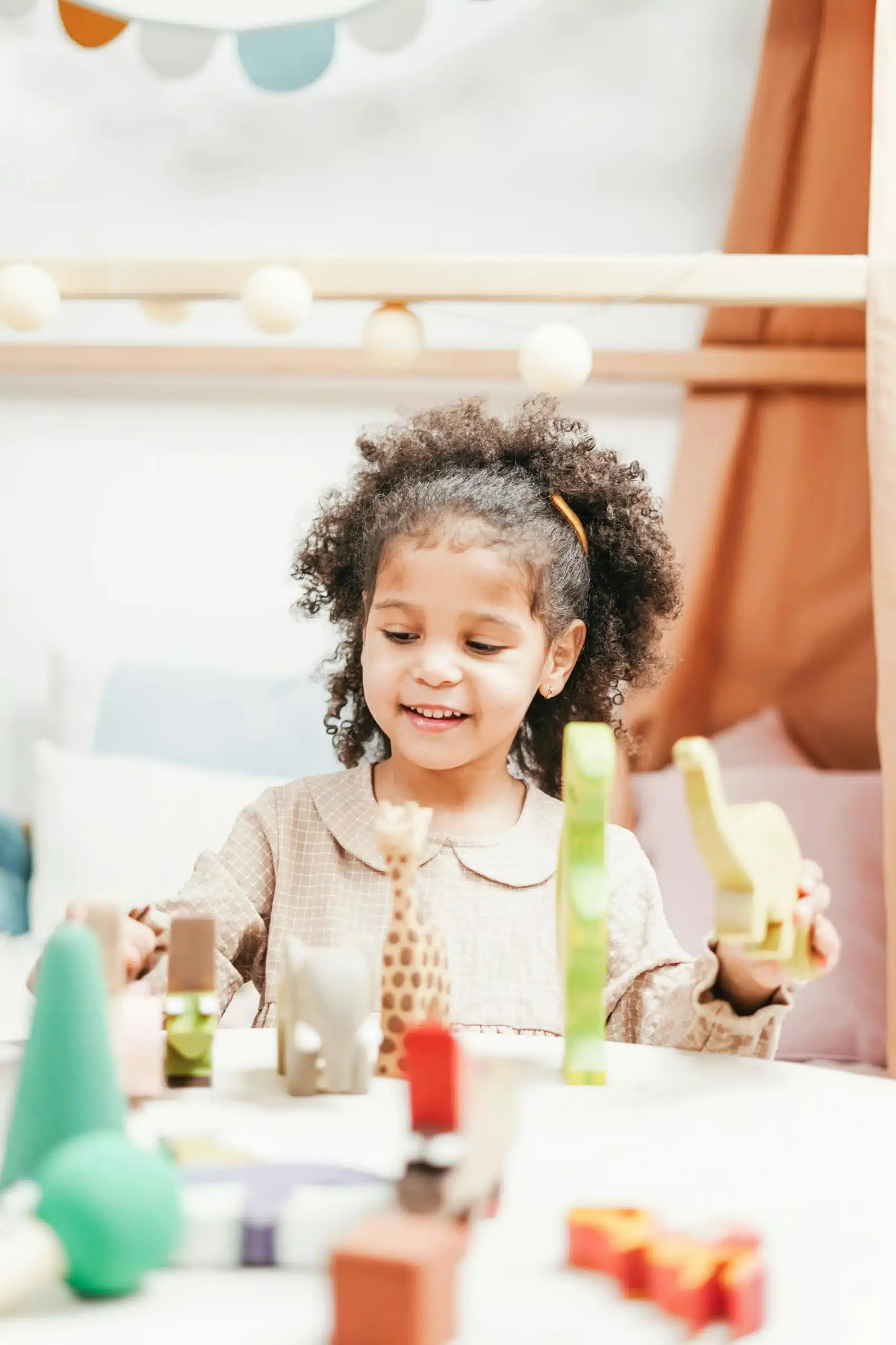 African American girl playing with animal blocks encouraging imagination learning problem solving and creative play skills