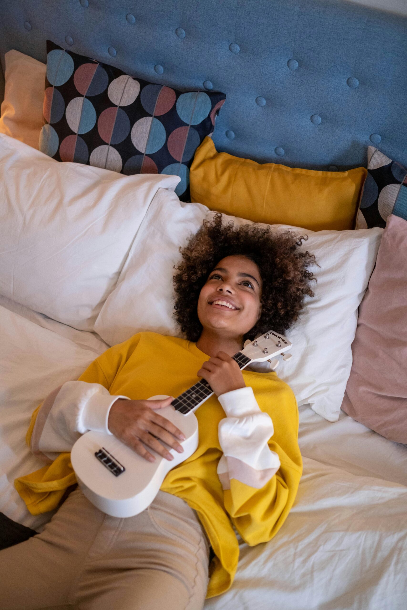 Girl in yellow sweatshirt with guitar