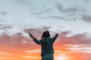 Person standing at sunset representing healing and emotional freedom in trauma informed therapy