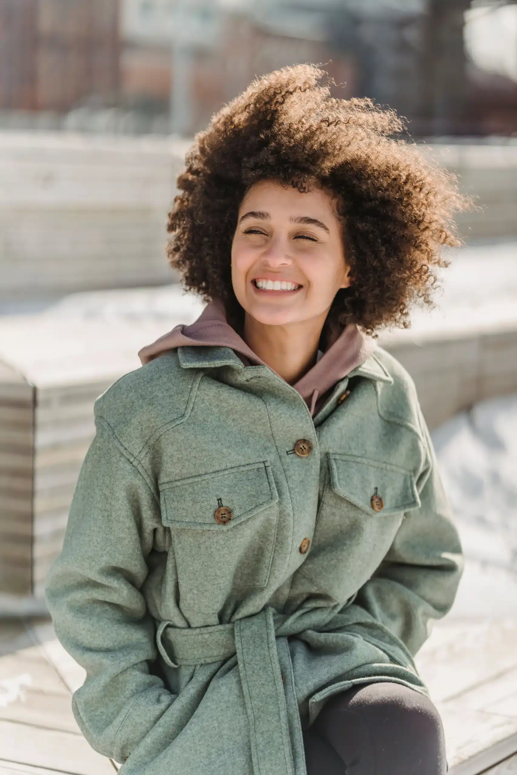 A smiling woman in casual professional attire outdoors, representing the approachable and friendly