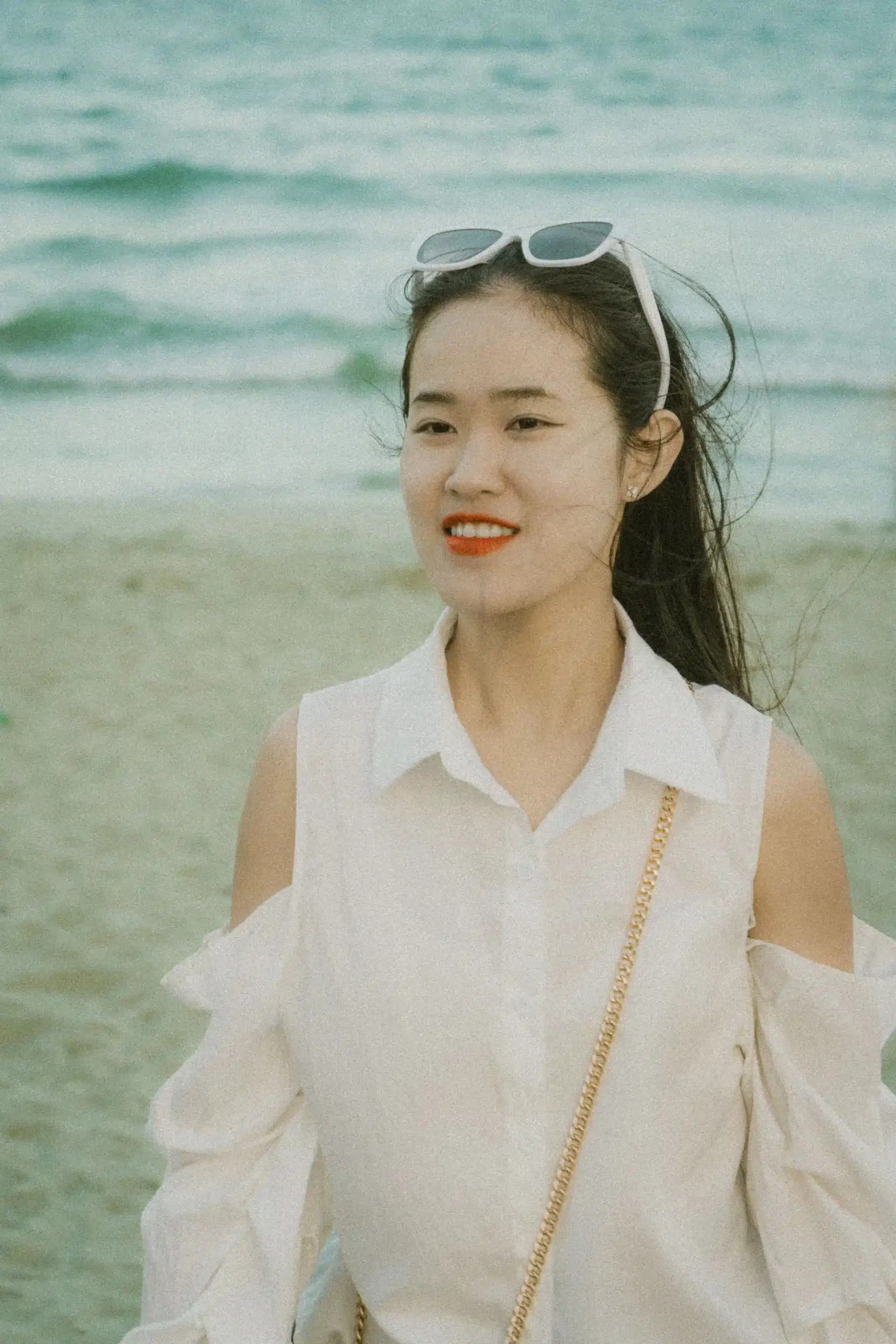 A young woman in a white off-the-shoulder shirt with sunglasses