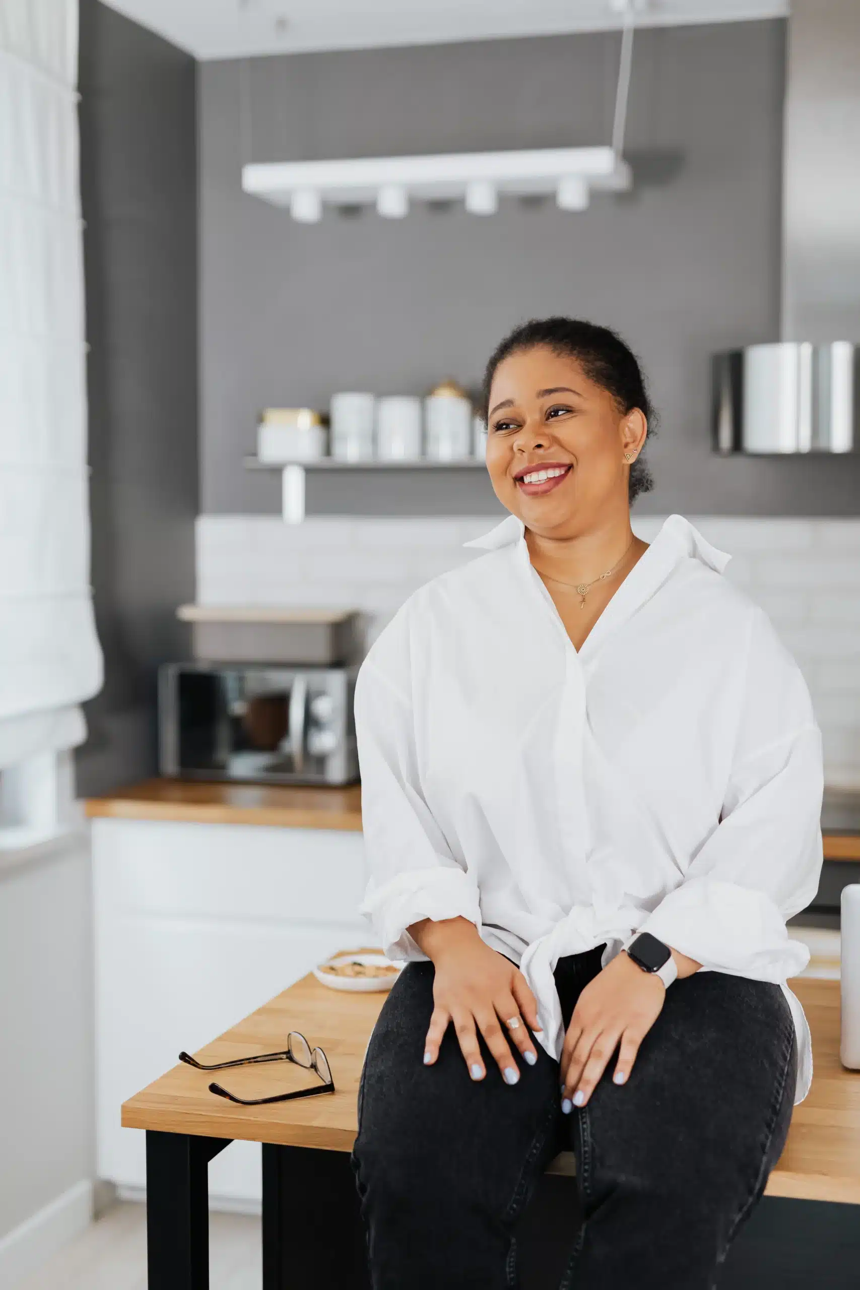 Friendly and confident business professional sitting on a desk