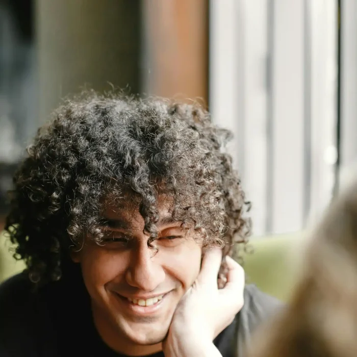 Man smiling softly and someone holds his face