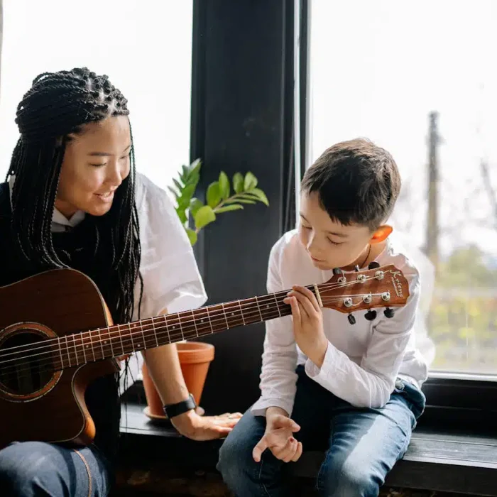 Teenager singing or using a keyboard with a supportive therapist